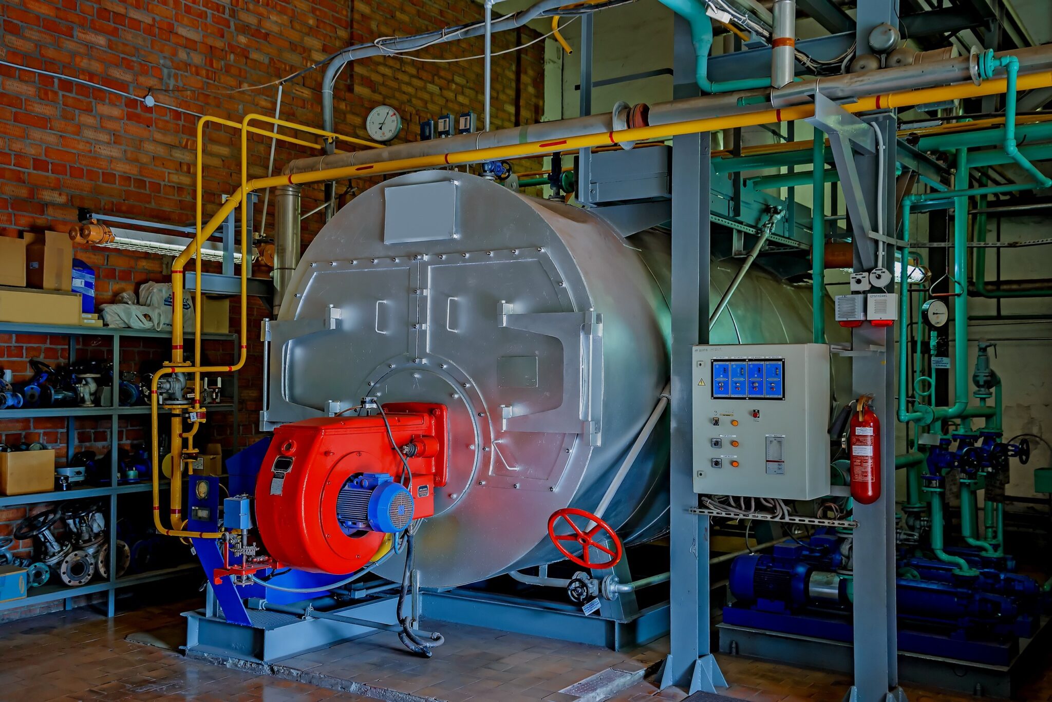 Commercial boiler with burner and control panel in a mechanical room