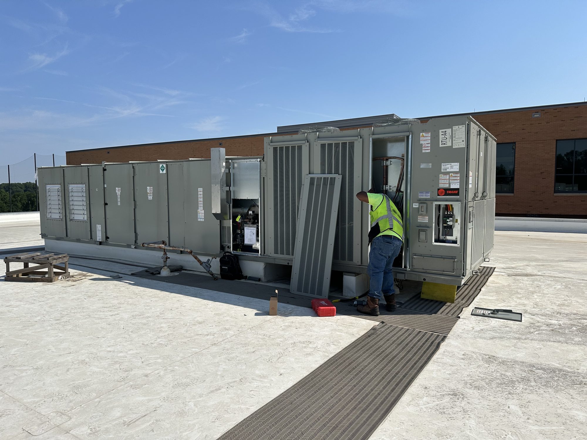 Commercial Tech technician servicing Trane rooftop unit RTU-A4